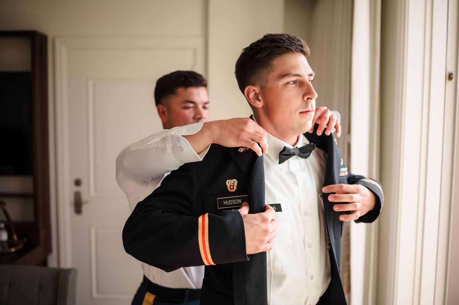 Groom laughing with groomsmen during wedding morning preparations