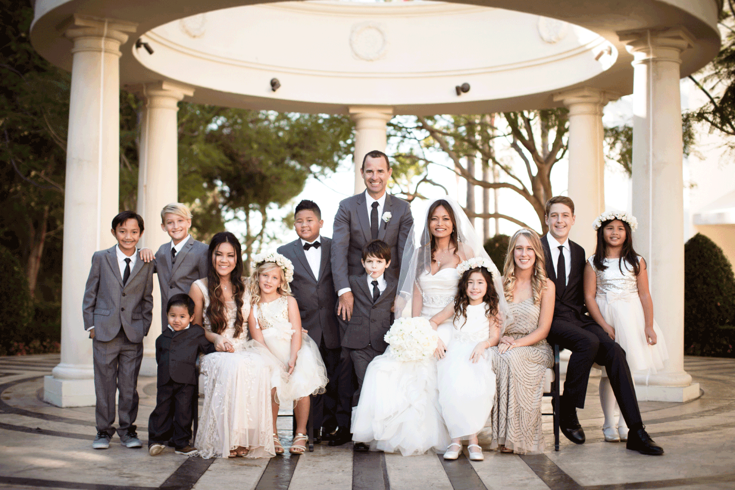 Large wedding group photo with genuine expressions and warm energy
