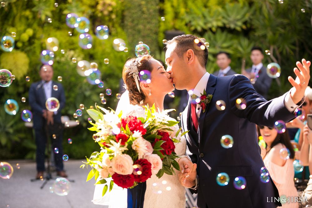 A Chinese couple kissing and getting married with bubbles gently floating above, set against a green forest background