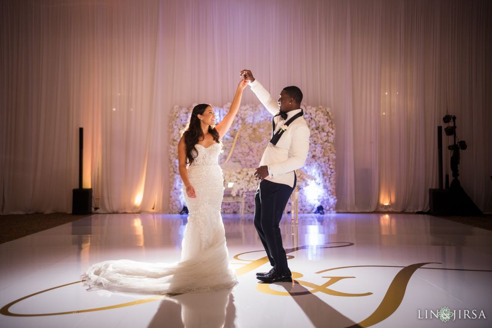 Wedding reception dance floor decorated with white flowers with soft purple lighting by Lavish Weddings, a San Diego, California luxury event planner