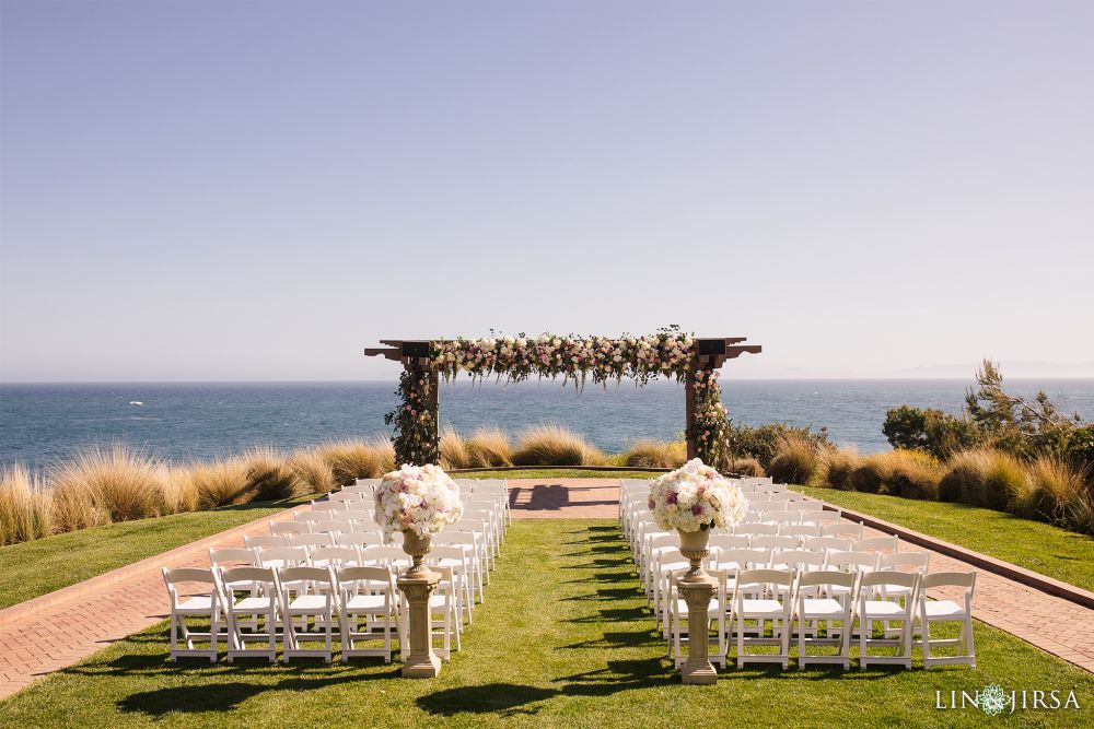 A beautiful wedding altar, at the Terranea Resort in Palos Verdes with white chairs in two columns, facing the altar, with the ocean, in the background