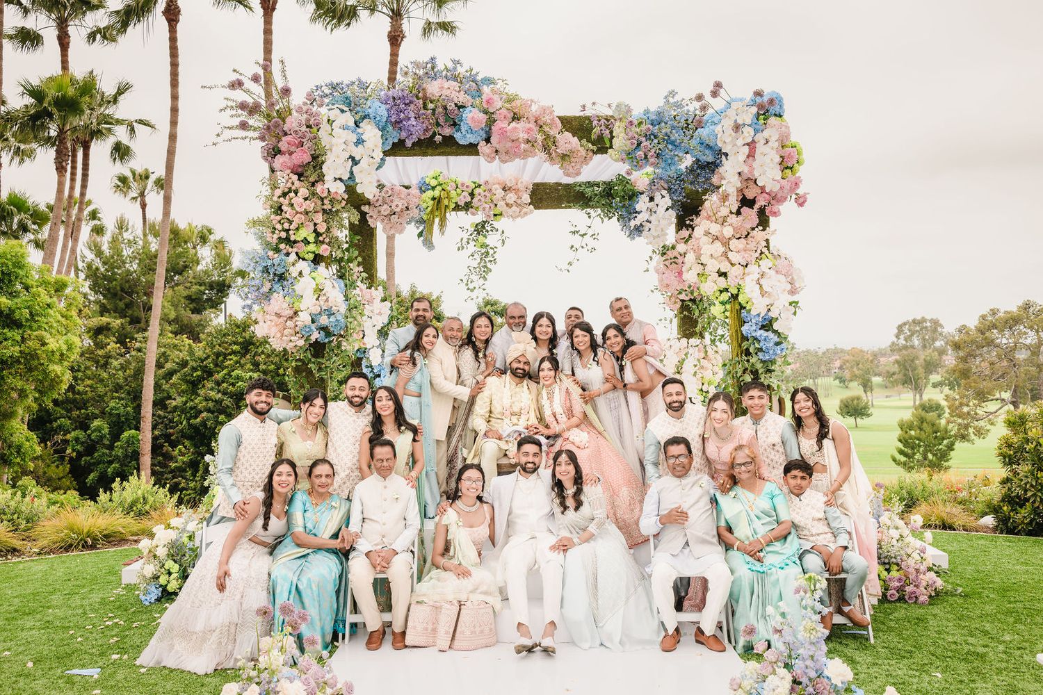 Large South Asian extended family group photo coordinated warmly and efficiently in beautiful light