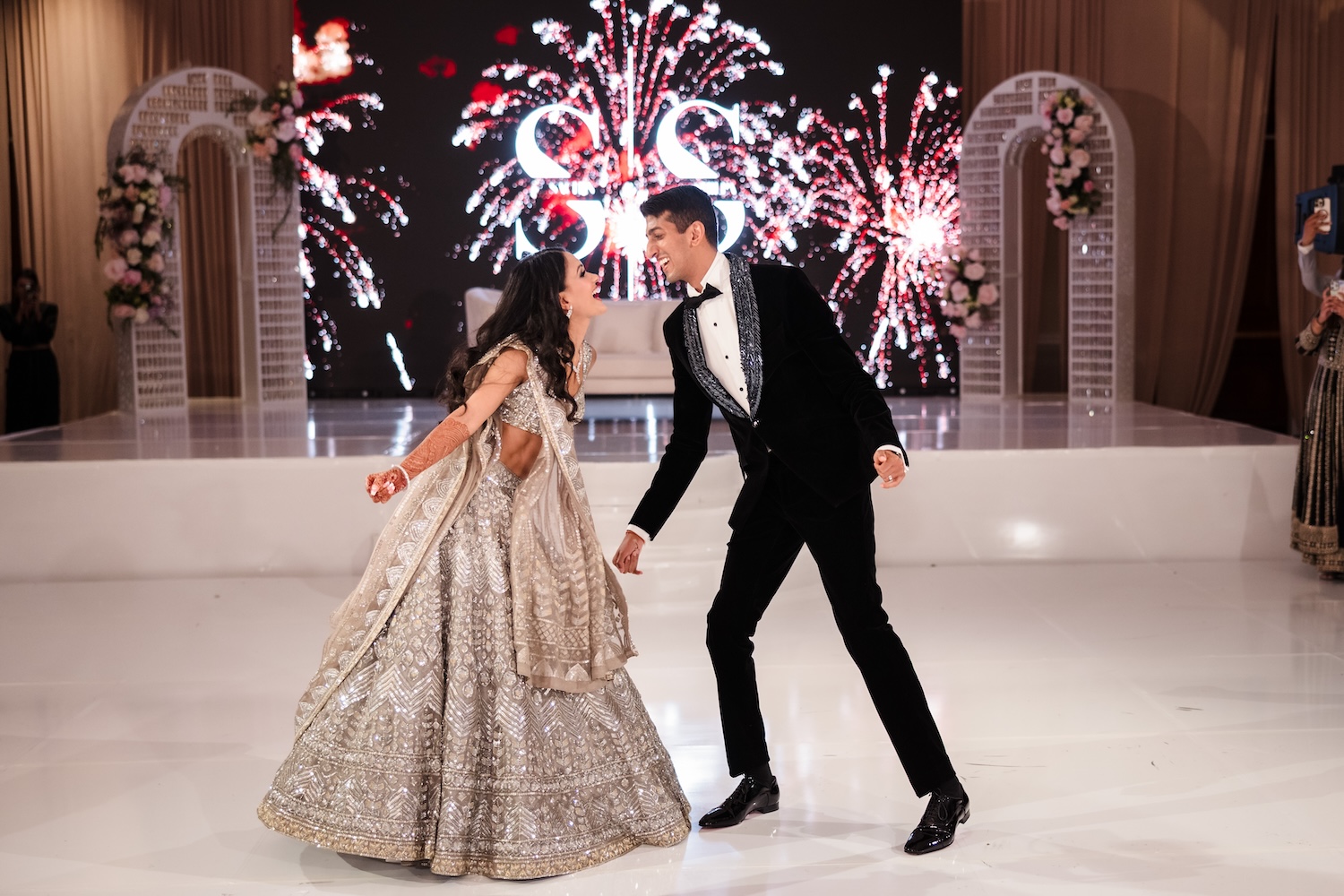 Couple's first dance at an Indian wedding reception captured in the warm glow of the ballroom