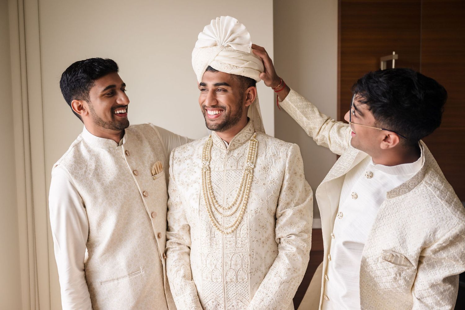 Groom laughing with his groomsmen in a candid moment before the ceremony begins